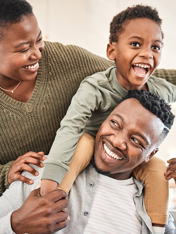 Shot of a happy young family playing together on the sofa at home.