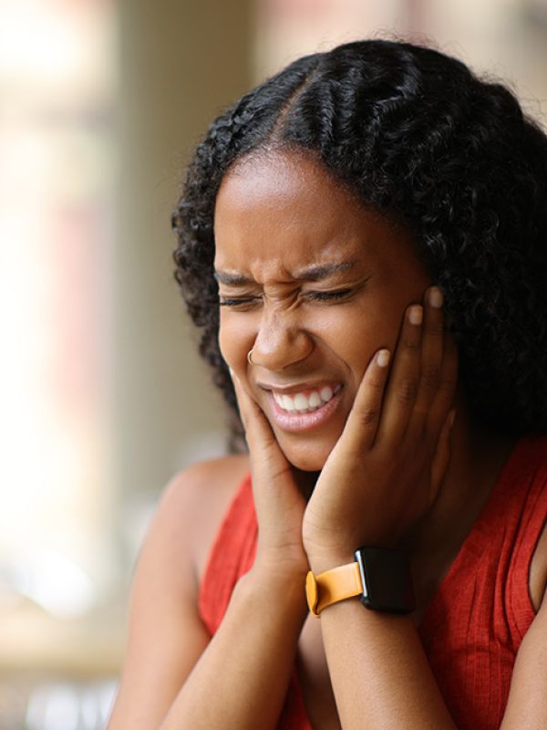 Black woman suffering tmj in a restaurant