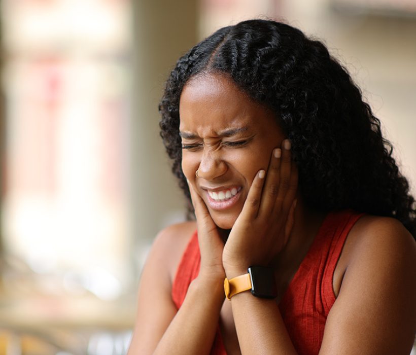 Black woman suffering tmj in a restaurant